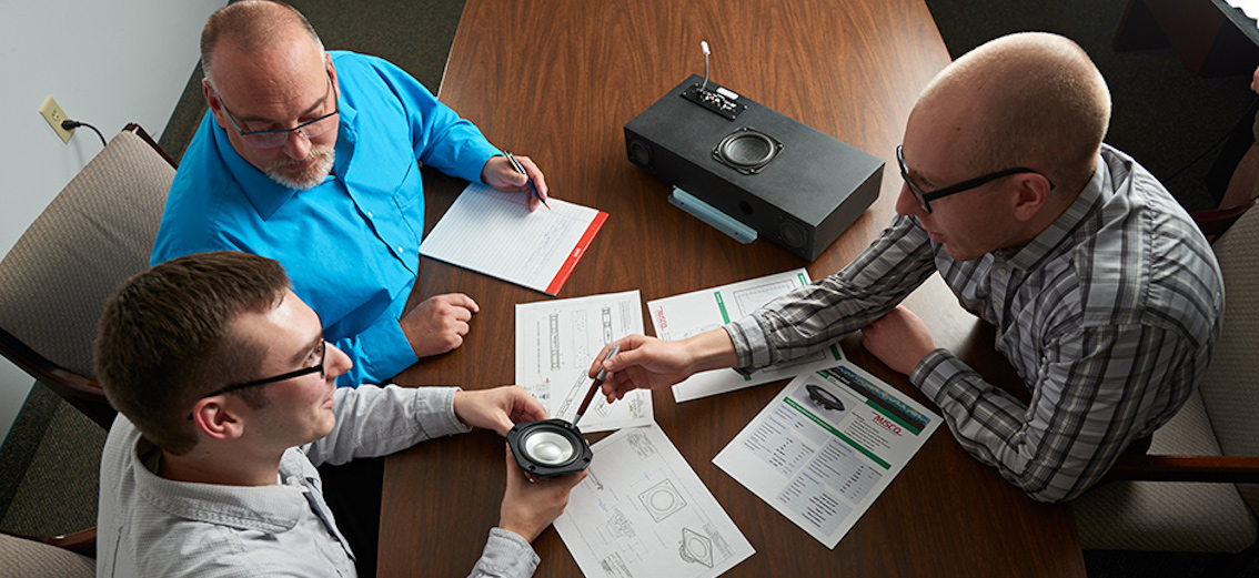 A group of MISCO engineers discussing a custom audio solution.