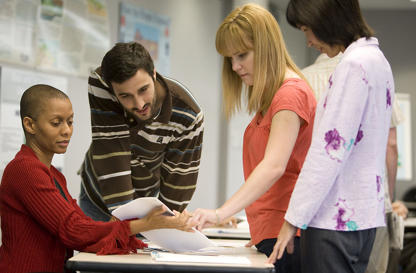 Employees examining a set of documents.